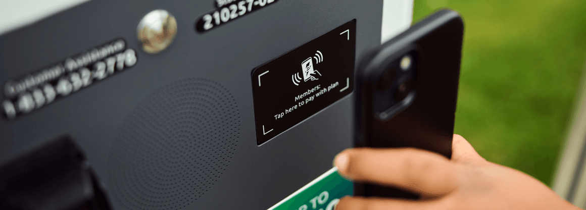 Person paying with their phone at an EV charging station
